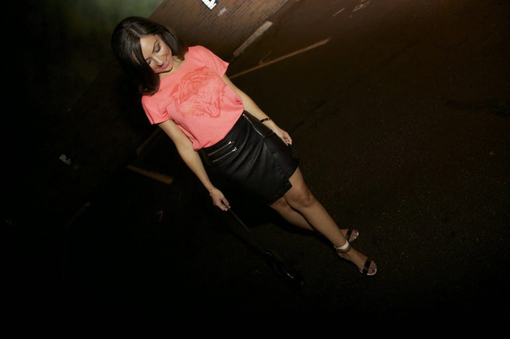 Blogger Nihan showing her trendy outfit - orange t-shirt, leather skirt and high-heels