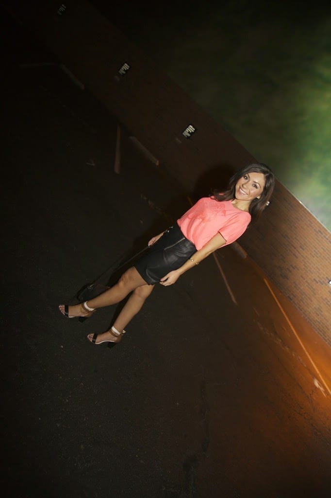 Blogger Nihan showing her trendy outfit - orange t-shirt, leather skirt and high-heels