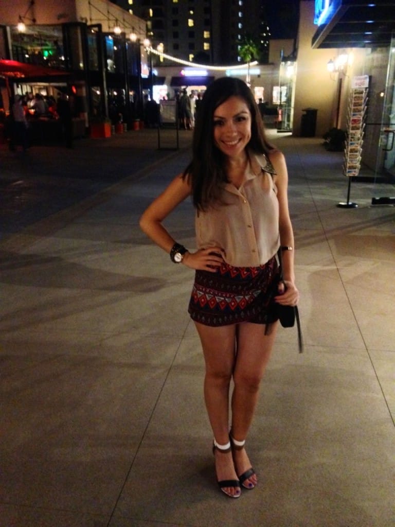 Blogger Nihan wearing an aztec printed mini shorts,  a neutral top and fun sandals while posing in Seaport Village San Diego