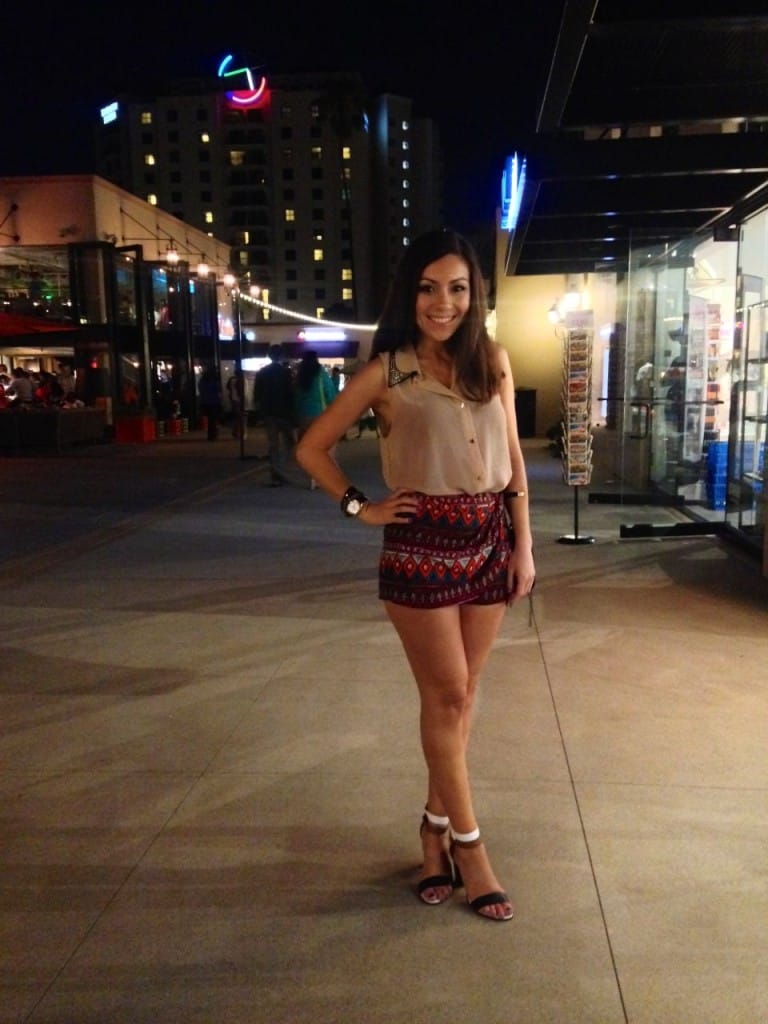 Blogger Nihan wearing an aztec printed mini shorts,  a neutral top and fun sandals while posing in Seaport Village San Diego