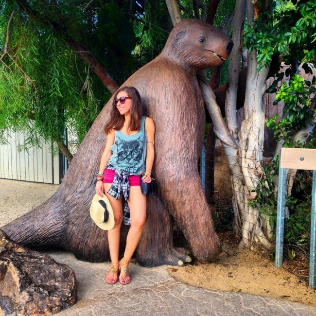 Blogger Nihan posing with the sloth and showing her outfit at the San Diego Zoo