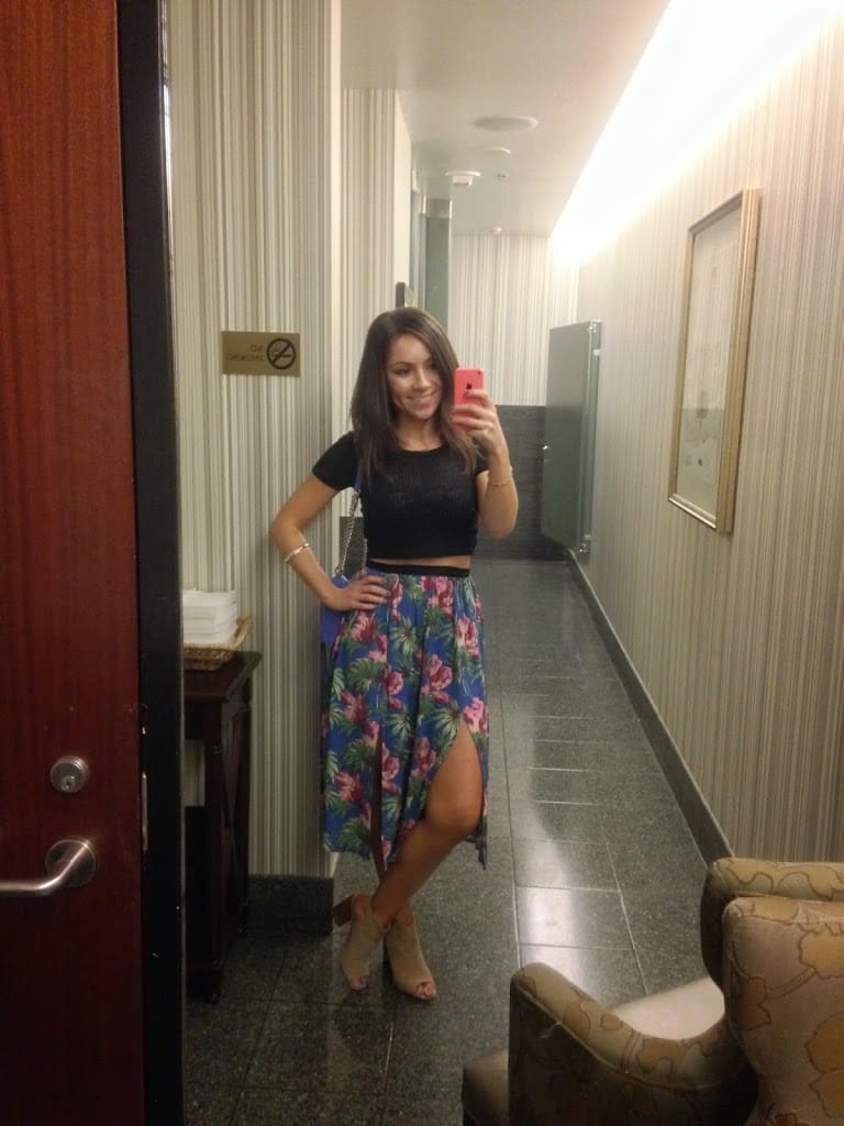Blogger Nihan posing in front of a graffiti wall and showing her outfit: a floral midi skirt by Topshop and a black crop top