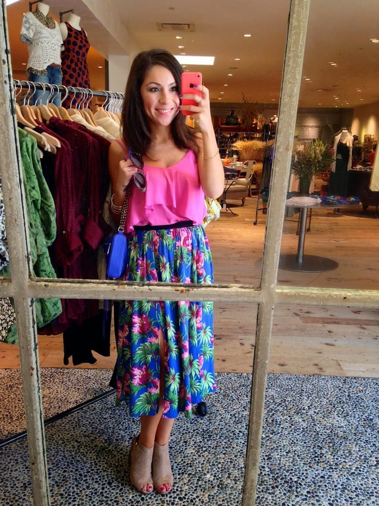 Blogger Nihan posing in front of a graffiti wall and showing her outfit: a floral midi skirt by Topshop and a pink tank top