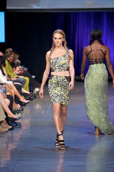 Model wearing a blue and green matching top and skirt walking down the runway during Fashion Week San Diego 2014 Night 3