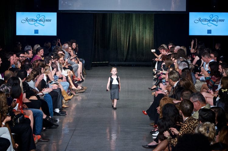 Little cute girl model walking down the runway on Fashion Week San Diego 2014 Night 2