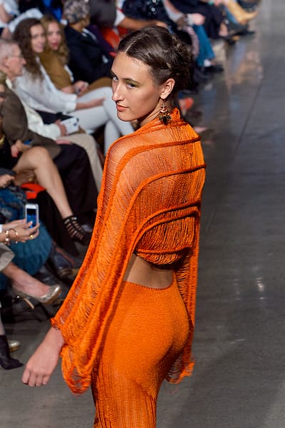 Model in orange dress walking down the runway on Fashion Week San Diego 2014 Night 2