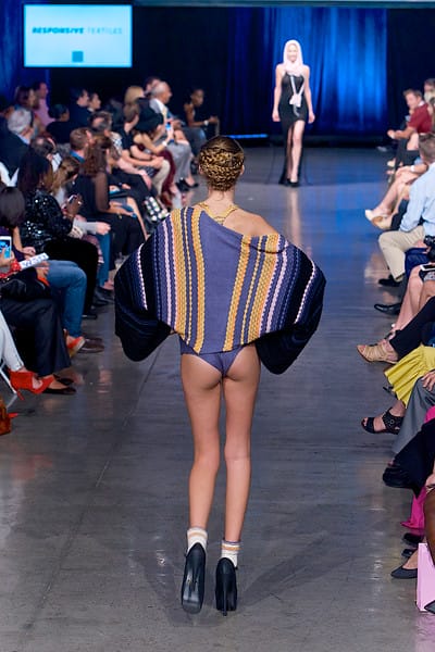 Model in purple printed knit swimsuit and matching kimono walking down the runway on Fashion Week San Diego 2014 Night 2