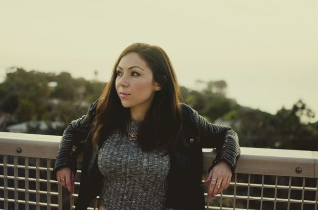 Blogger Nihan posing and showing her edgy and cool leather jacket and gray crop top
