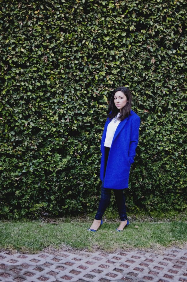 Nihan Gorkem wearing a coat standing in front of a grass wall