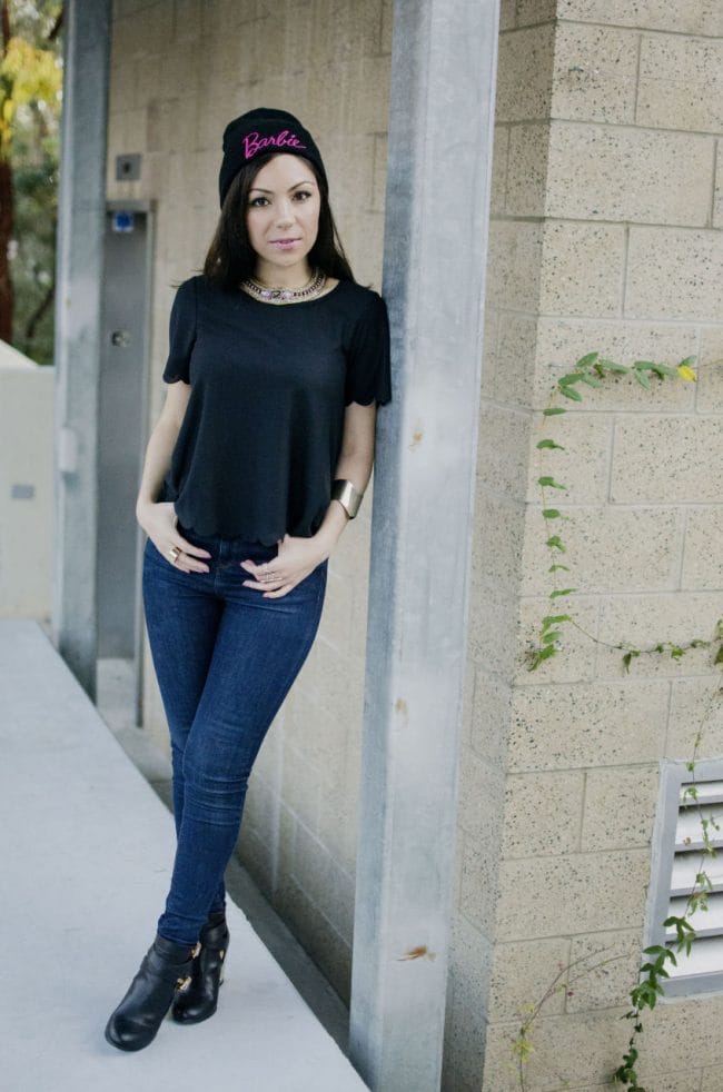 Girl standing on a wall and showing her outfit