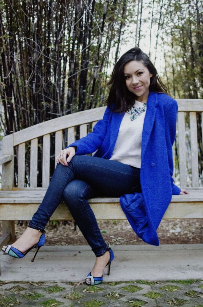 Nihan Gorkem wearing a blue coat sitting on a bench