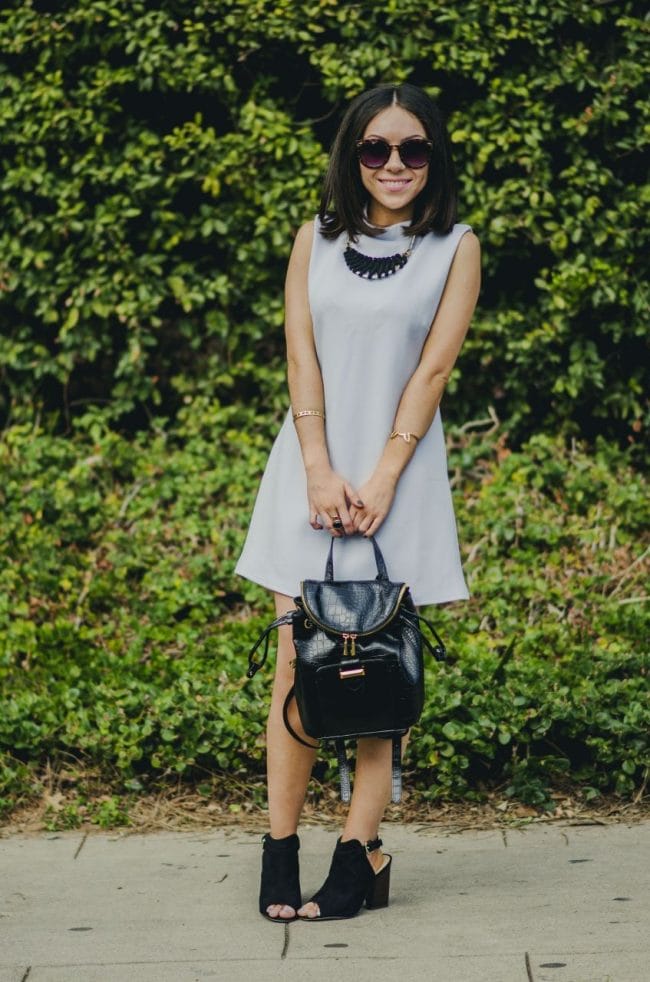 Nihan Gorkem wearing baby blue mod dress black gold backpack black open toe booties and smiling - winter baby blues