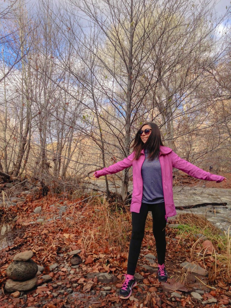 Blogger Nihan posing by the vortex in  Cathedrol Rock, Sedona, Arizona and showing her colorful hiking outfit