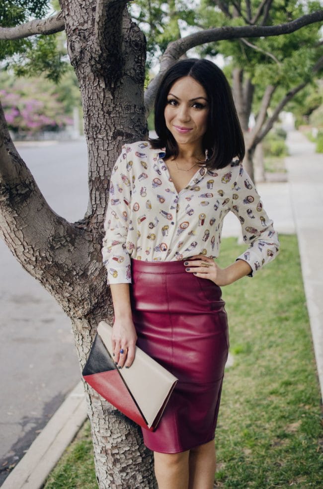 Blogger Nihan leaning on a tree, wearing a Zara owly shirt, Asos leather skirt and Asos colorblock clutch