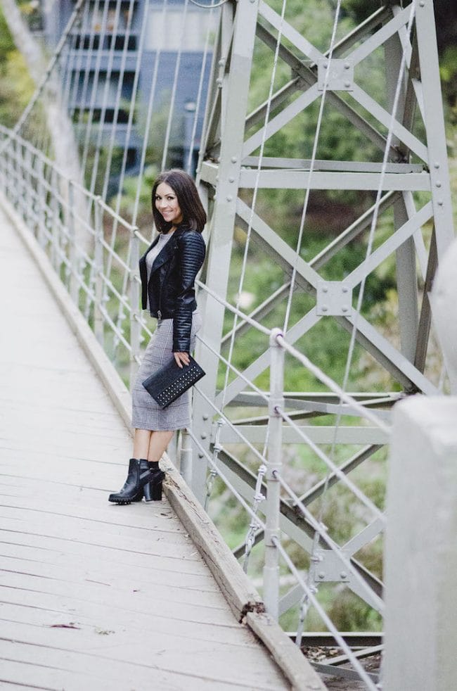 Blogger Nihan wearing Topshop grey midi skirt, grey top , black boots and leather Topshop jacket at the Suspension Bridge in San Diego
