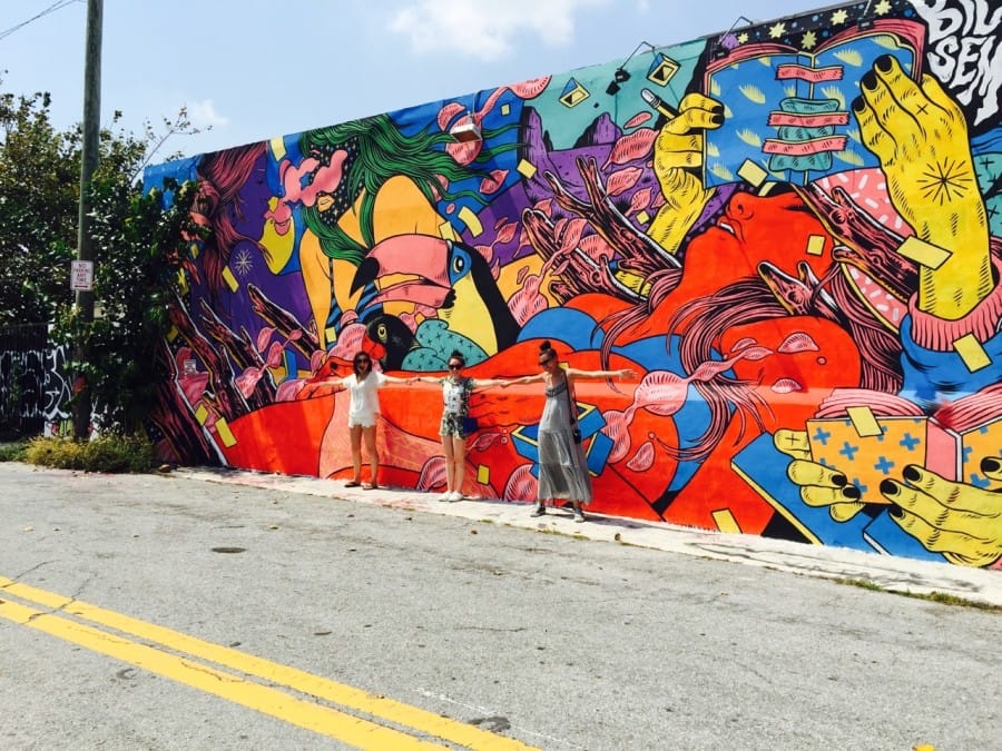 Nihan and friends posing in front a mural in Wynwood Walls, Miami