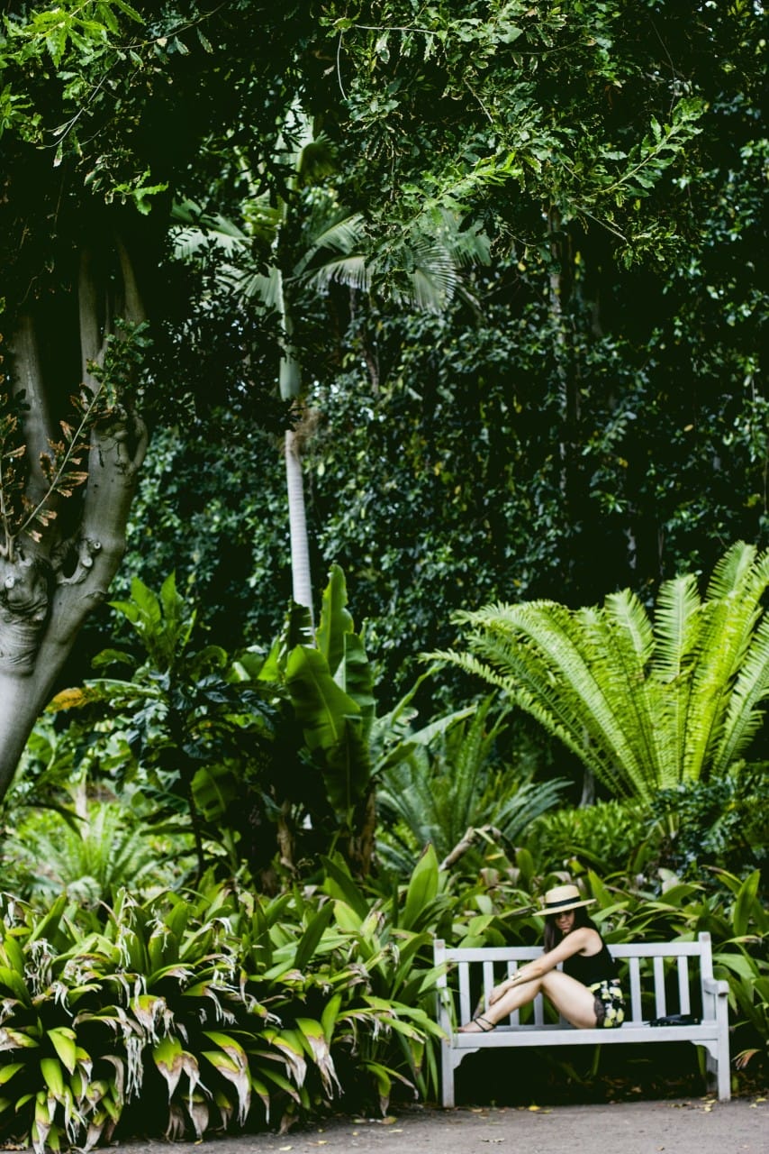 Nihan sitting on a bench at the Huntington Library and gardens Rainforest 