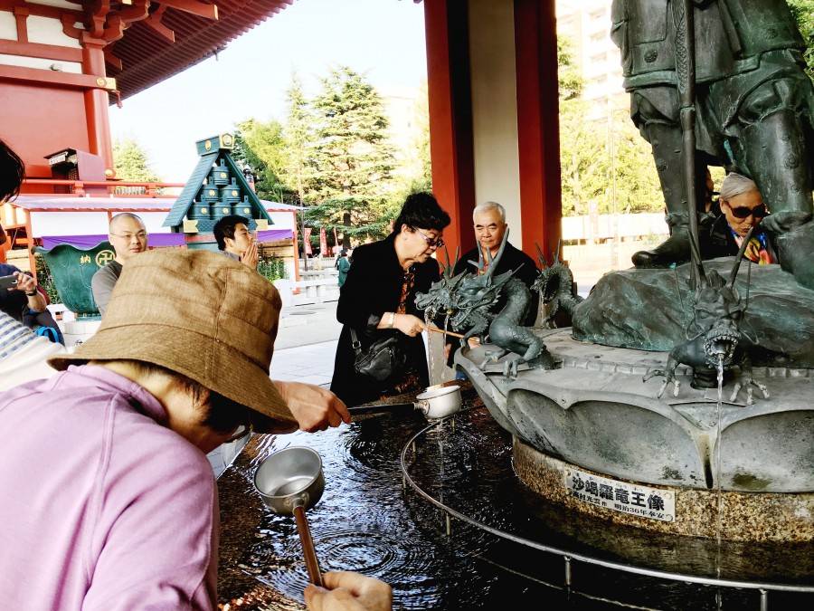 People drinking sacred water Sensoji asakusa buddhist temple